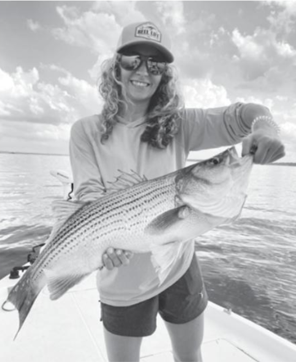 Mikale Edwards Holds a Hybrid Striped Bass Caught on Lake Conroe during Fishing with Lake Conroe Fishing Adventures